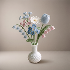 Handmade crochet new baby bouquet of soft blue and pink pastel flowers in a vase