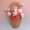 Hand-crocheted Forever Rose Bouquet: three full rose stems with pink and red blooms in a kraft sleeve